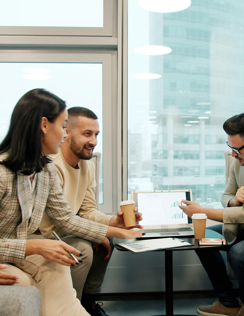 Men and women multiracial team with to go coffee are discussing business in shared office
