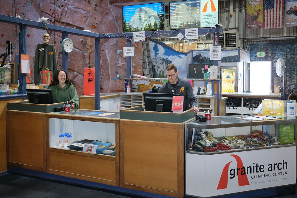 One staff member working on the computer at the front counter. The other staff member is looking over and smiling