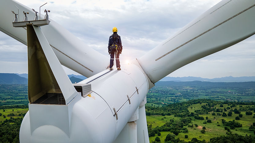 Female Inspection engineers standing on top of a wind turbine and looking beautiful lands