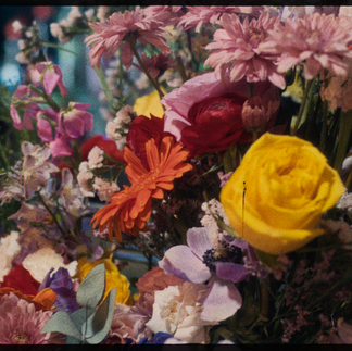 Close-up of a vibrant bouquet featuring premium flowers from URKU expressions, including a yellow rose, orange gerbera, red ranunculus, and pastel summer flowers. The image captures the richness and diversity of textures and colors used in the Mother’s Day campaign celebrating self-built women.
