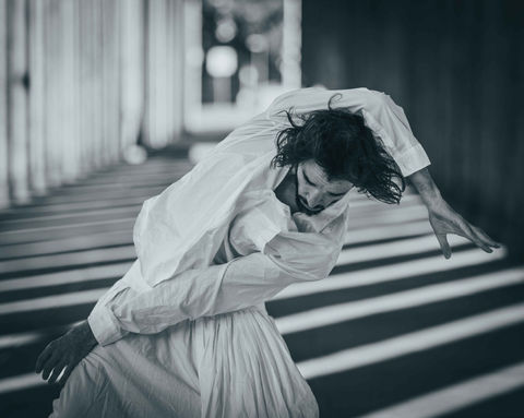 eine dynamische Fotografie eines Tänzers, der in einem Säulengang tanzt