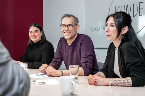 das Bild zeigt diverse Personen während eines Meetings. Das Bild ist ein schönes Beispiel für eine Corporatefotografie.