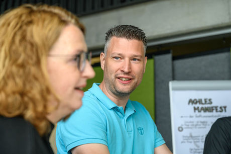 das Businessfoto zeigt einen Mann und eine Frau während eines Meetings