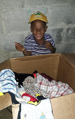 Smiling Dominican boy excited to receive donated supplies from Ana's Cleaning Services