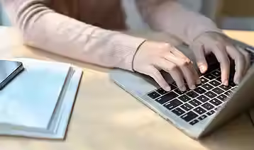 imagem-recortada-de-uma-jovem-estudante-universitaria-asiatica-usando-um-laptop-digitando-