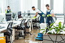 multicultural team of cleaners working in modern open space office.jpg
