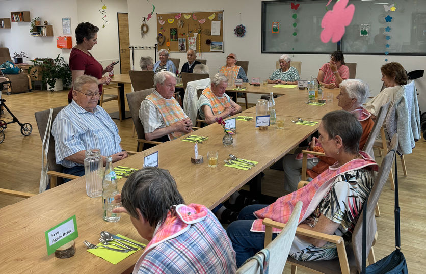 Tagespflege-Gäste die am Tisch sitzen und auf das Mittagessen warten