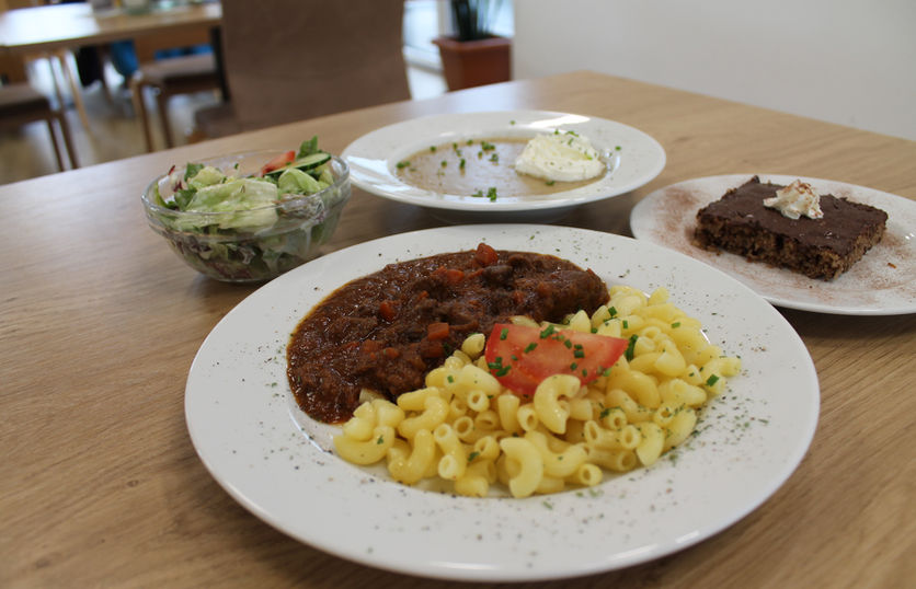 Mittagessen in der Tagespflege, ein Teller Suppe, Salat, Gulasch und Kuchen