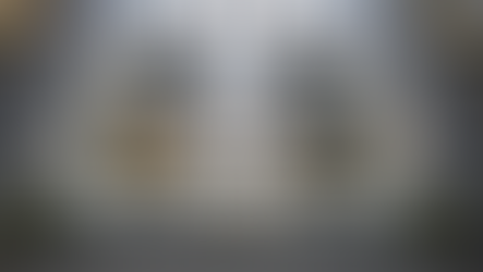 Expedia Group office building facade with glass windows and plants inside. Large white "expedia group" text on the exterior in a modern setting.