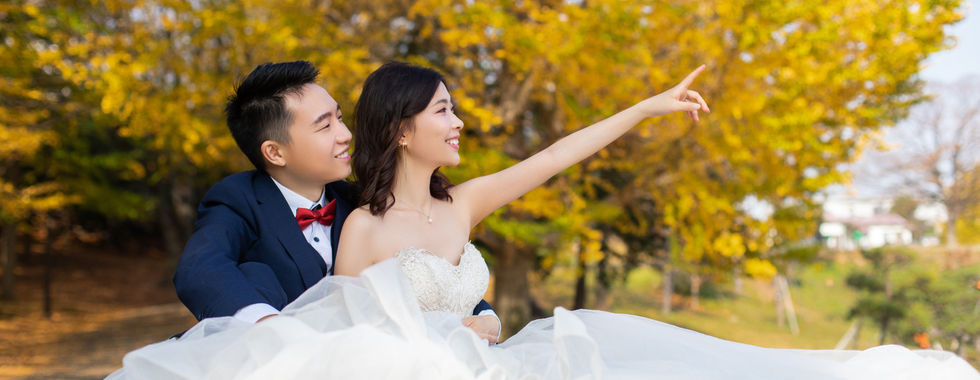 新人在金黃銀杏樹下拍攝秋季浪漫婚紗照。