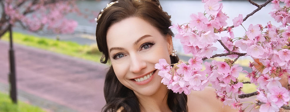 新娘在春季粉色櫻花中拍攝優雅婚紗肖像。