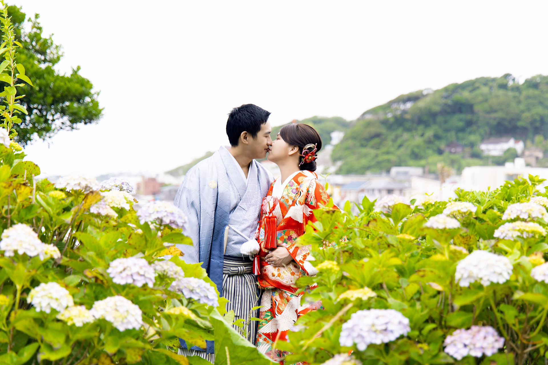 鎌倉の海辺と紫陽花を背景に寄り添うカップルの日本前撮り写真