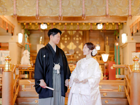 日本の神社で神前式を行う新郎新婦。白無垢や色打掛などの伝統的な婚礼衣装を着用し、プロカメラマンが挙式を撮影している様子。