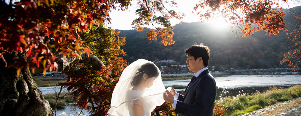 Bride and groom sharing a quiet moment beneath towering bamboo in Kyoto’s Arashiyama district.
