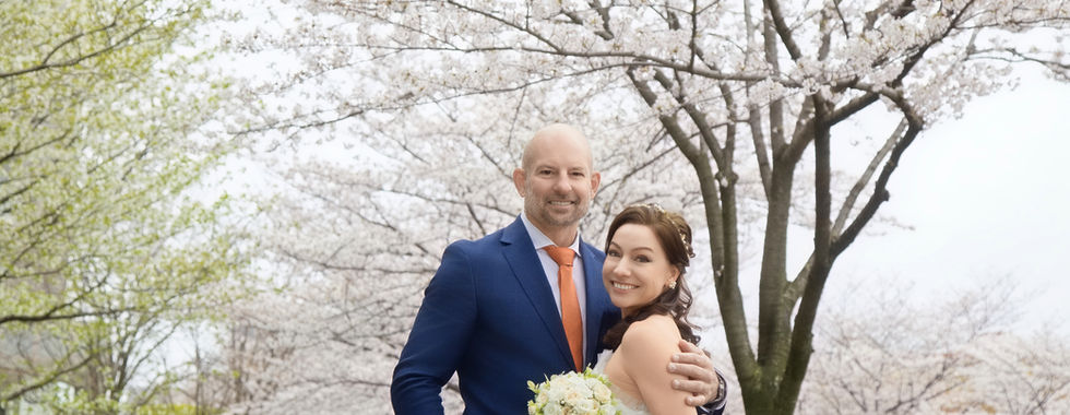 新人在白色櫻花樹下拍攝柔和浪漫婚紗照。