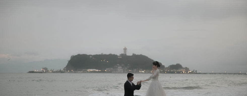 新人在夕陽海灘拍攝電影感求婚剪影婚紗照。