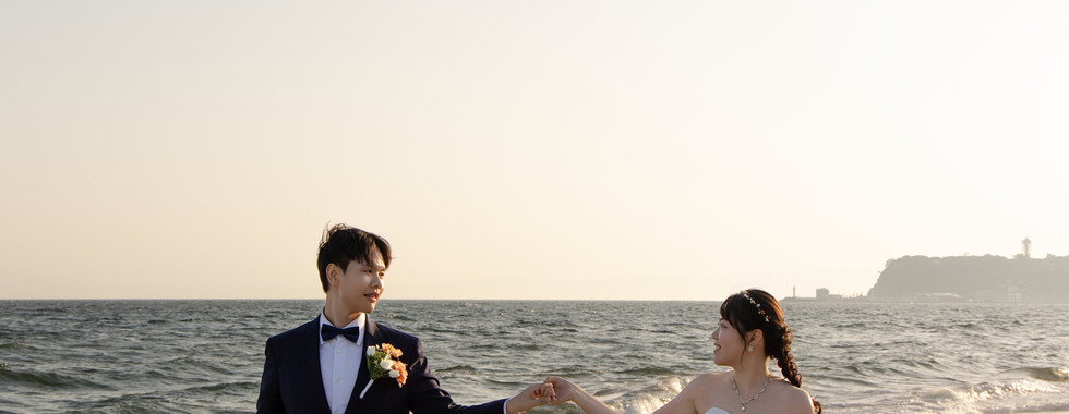 Romantic couple walking together along Shichirigahama Beach during a Kamakura pre-wedding photoshoot.