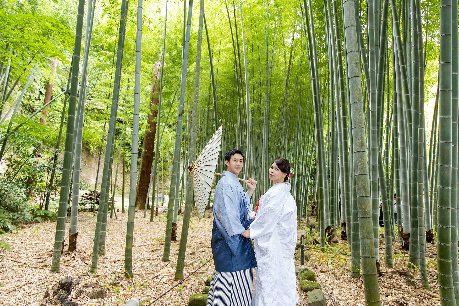 Bride and groom holding hands in a quiet bamboo forest during a Kamakura pre-wedding photoshoot.