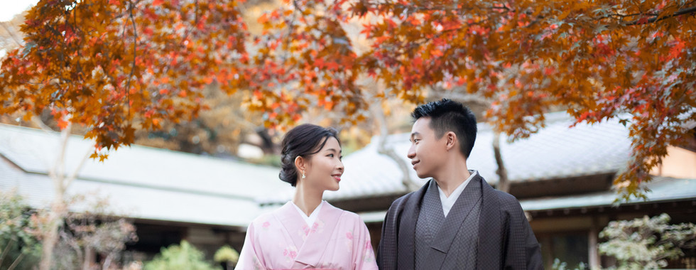 Couple in kimono surrounded by colorful autumn foliage during a Tokyo autumn wedding photoshoot.