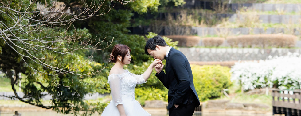 Bride and groom walking together beside the historic red brick buildings in Yokohama.