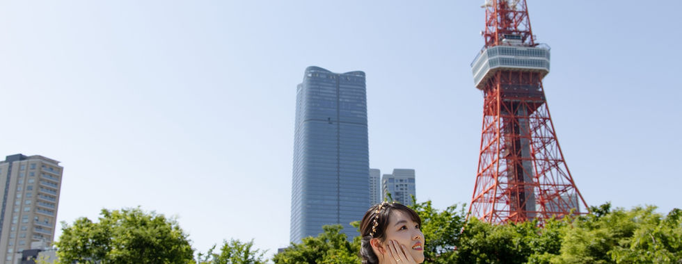新娘以東京鐵塔與綠意為背景拍攝優雅婚紗肖像。