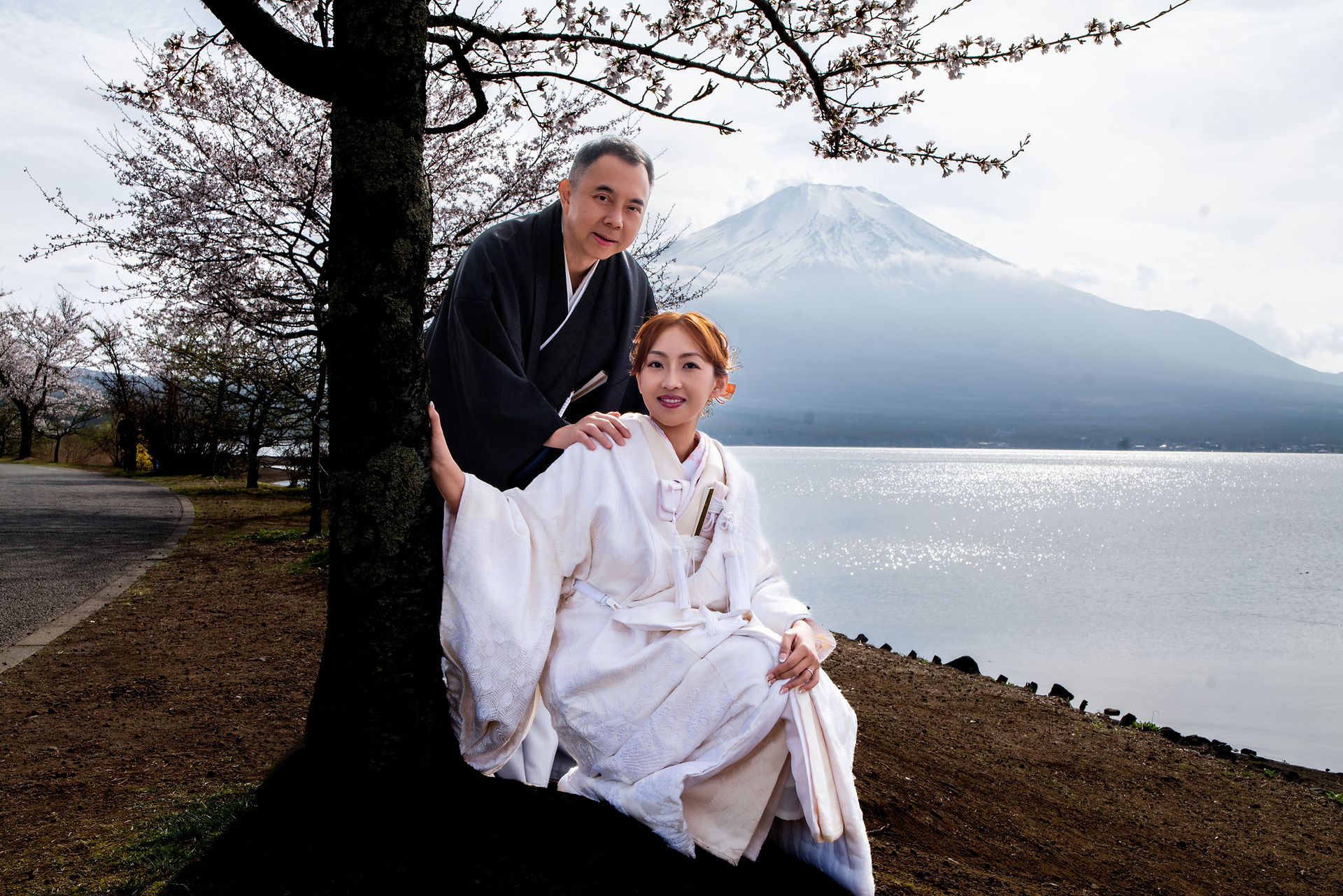 河口湖と富士山のそばで和装婚礼衣装を着たカップル