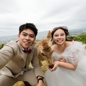 cheerful couple selfie portrait with deer at nara park