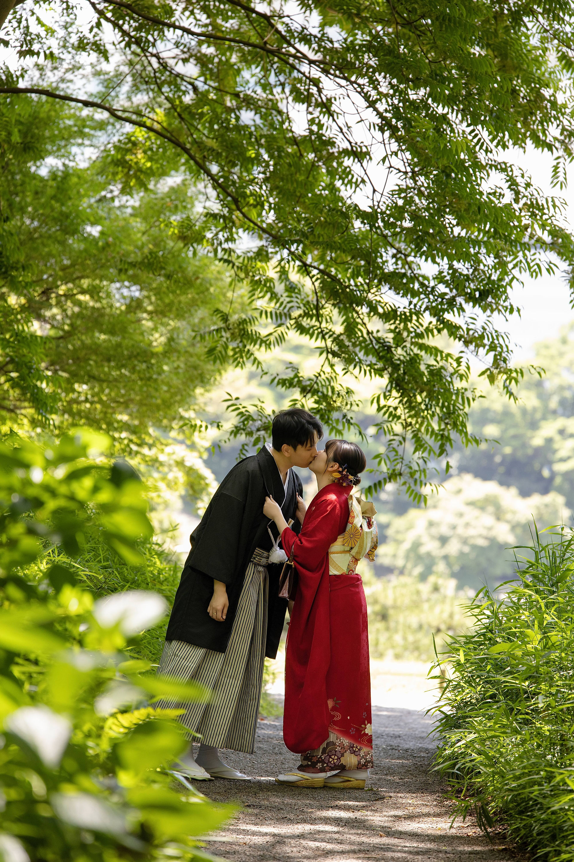 新人穿著和服在日式庭園木橋旁拍攝傳統婚紗照。