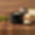 Black keystone Keystone Cream jar on wooden cutting board with herbs and spoon