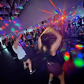 Women dancing in a dark fitness studio with colourful party lights and energetic music, in Brookvale, Northern Beaches.