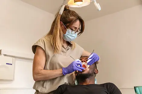White Dental clinician providing urgent dental care to a patient.