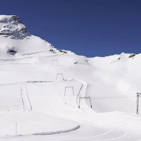 Sneeuwbedekt berglandschap op Zugspitze met liftpalen en sporen onder een heldere blauwe lucht.