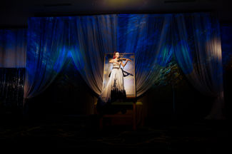 Live projection mapping creates a breathtaking reveal moment as a performer appears through illuminated sheer draping at the Grand Hyatt Deer Valley. This unique audio visual rental showcases our stage design capabilities, combining dramatic blue lighting with theatrical fabric elements. Our Park City AV specialists bring creative vision to life for high-end events throughout Utah.
