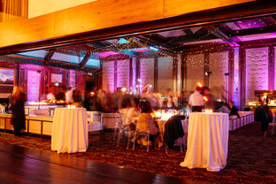 Elegant cocktail reception glowing with warm amber uplighting and bistro string lights in Park City. Event lighting rental Utah and full-service audio visual production create inviting atmospheres at mountain venues.