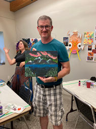 July 15, 2023 Parks Day Paint Party participant proudly shows his painting