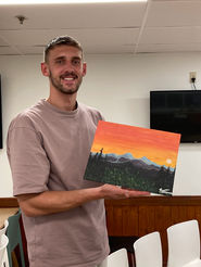 Paint Party participants shows off his mountain sunset painting