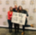 Picture of the owner with two female students holding a supportive sign.