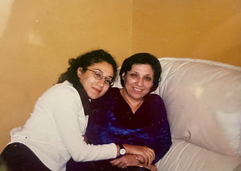 My mum and myself smiling and me hugging her on our white couch, in our lounge. Cozy mood.