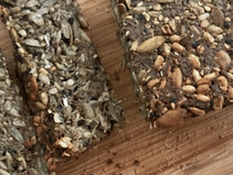 Sliced seedy protein bread made with flax, chia, sunflower, and pumpkin seeds on a wooden board