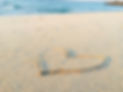 A heart drawn in the sand on a beach.