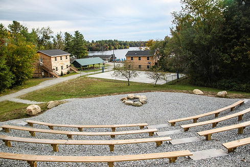 An outdoor amphitheater with bench seating overlooking a lake