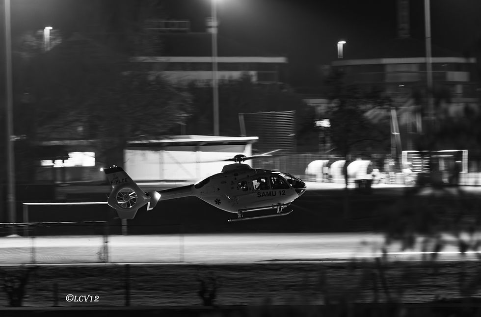 Hélicoptère du SAMU 12 photographié de nuit en mouvement, image en noir et blanc réalisée en filé à Millau.