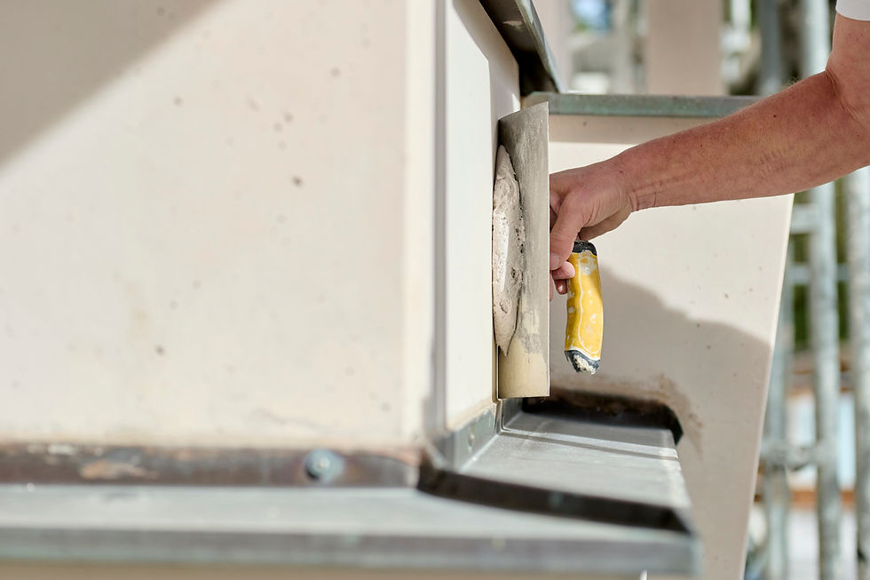 Ein Maler der eine Betonbrüstung spachtelt