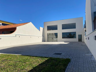 Fachada de obra comercial de 2 andares em branco, com janelas grandes.