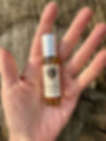 Hand holding Wild Moon Medicine Muladhara Root Chakra anointing oil 0.25 oz