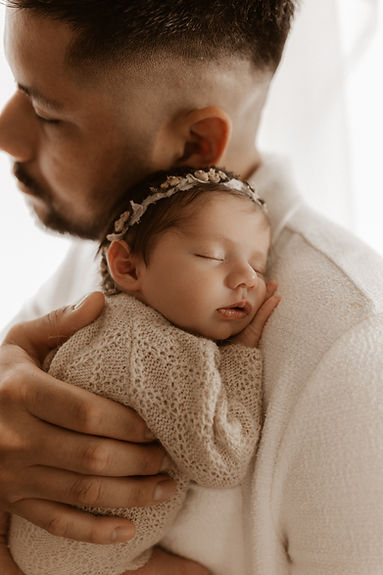 Dad snuggling his newborn girl