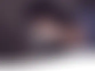 Kind liegt im Bett in einer dunklen Umgebung und schaut auf ihr Handy welches hell in das Gesicht scheint