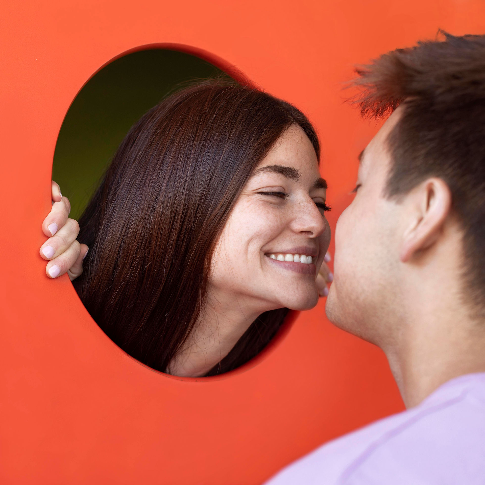 Invitados divirtiéndose frente a un fondo multicolor para fotos y selfies en evento social