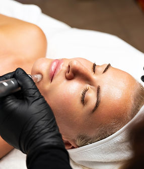 Microneedle RF lifting procedure. A cosmetologist performs a facial rejuvenation procedure