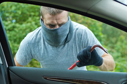 Aspen Sound technician installing advanced car alarm wiring under dashboard